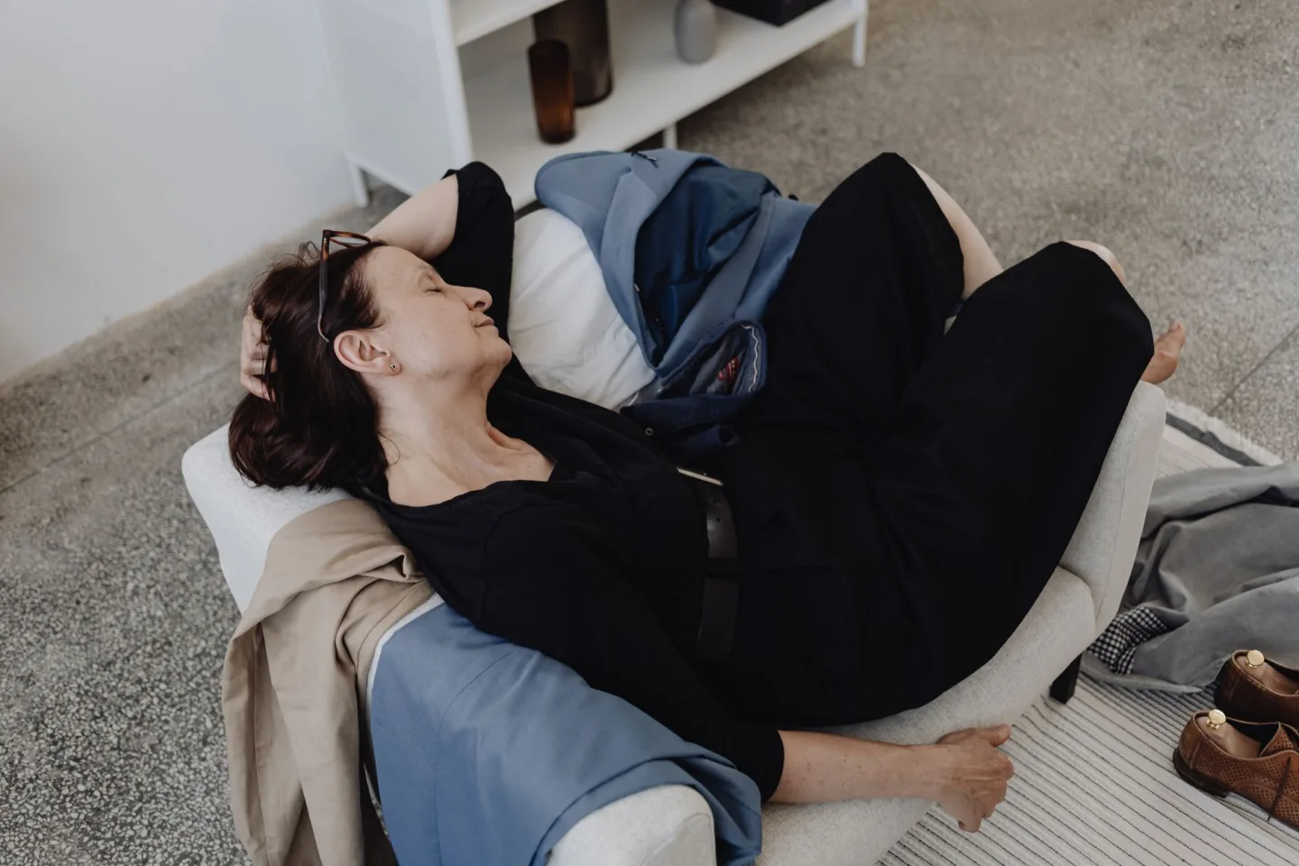 A parent resting on a sofa at home