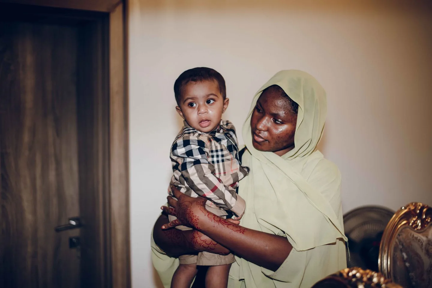 A parent holding their child at home